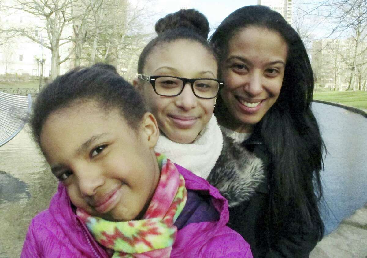 In this March 21, 2016 photo, Adelaida Torres, right, poses with daughters Elizabeth, left, and Gloria, center, in Hartford, Conn. Torres believes she never would have won custody of her two daughters in 2013 during a bitter court fight with her now-ex-husband if not for the free legal help from attorney Linda Allard and Greater Hartford Legal Aid. Connecticut lawmakers are considering a bill that would create a task force to look into expanding the right to free lawyers for the poor in civil cases.