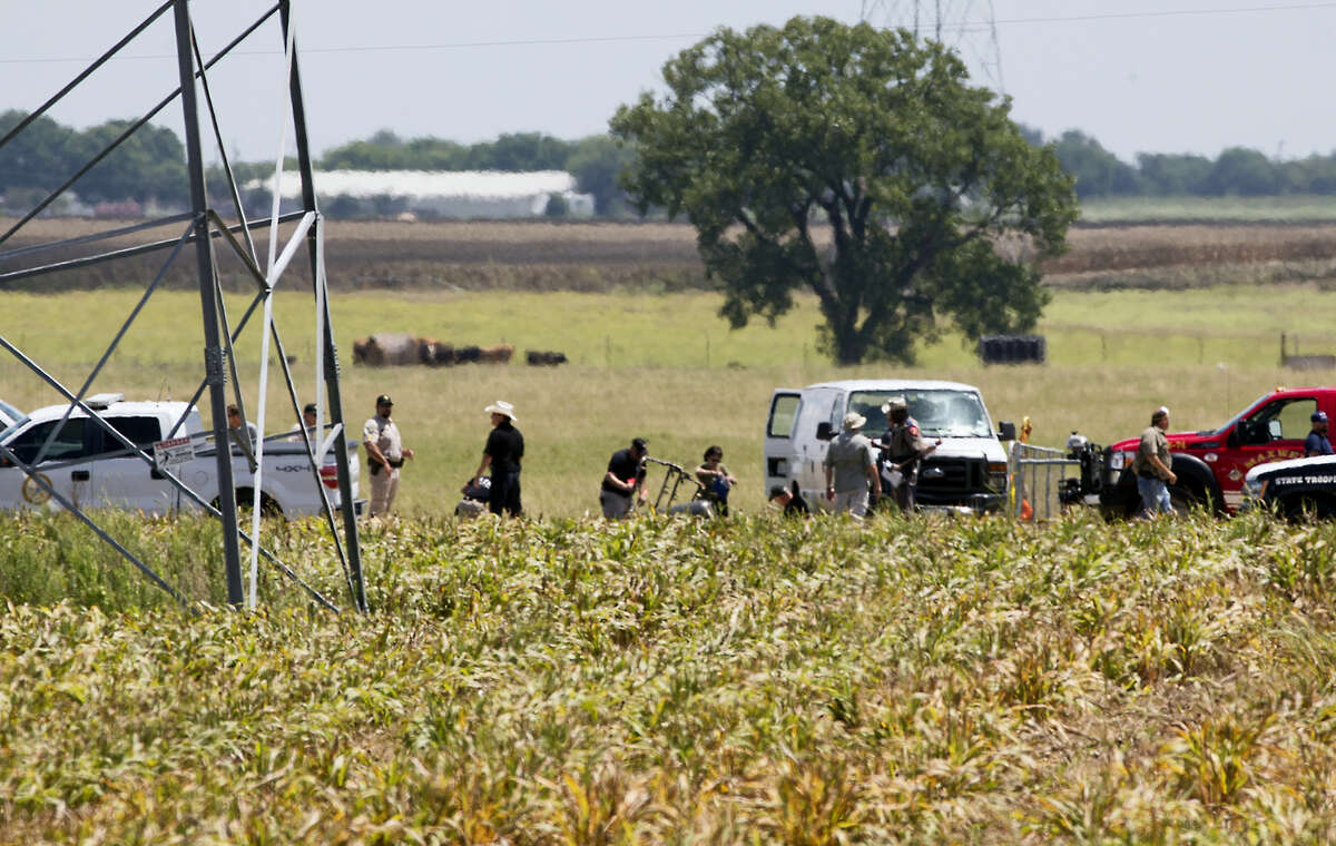 The partial frame of a hot air balloon is visible above a crop field at the scene in a field near Lockhart, Texas where a hot air balloon carrying at least 16 people collided with power lines Saturday, July 30, 2016, causing what authorities described as a “significant loss of life.”