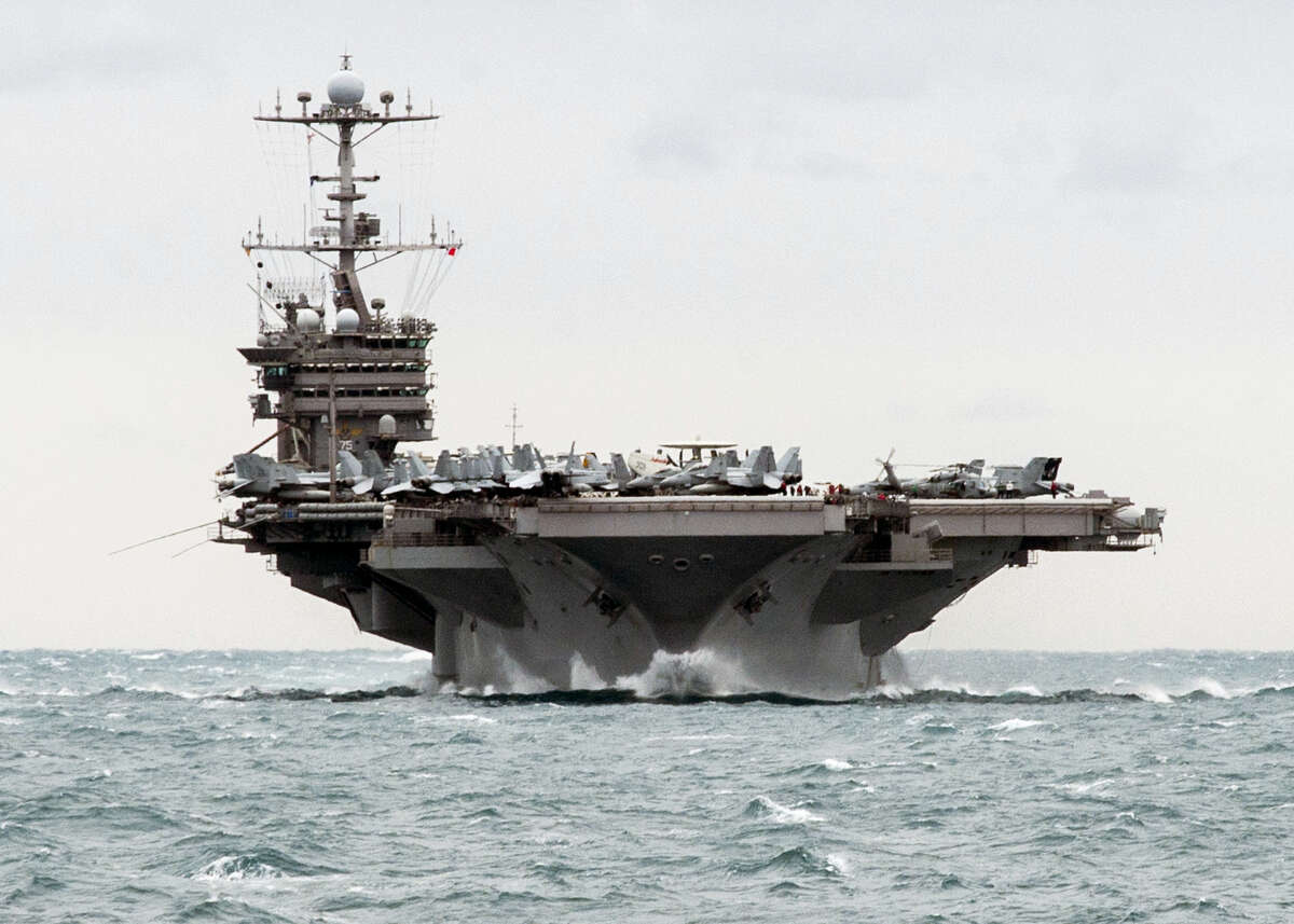 In this Saturday, Dec. 26, 2015 photo released by the U.S. Navy, the aircraft carrier USS Harry S. Truman transits the Strait of Hormuz. Iran flew a surveillance drone over a U.S. aircraft carrier and took “precise” photographs of it as part of an ongoing naval drill, state television reported Friday. The U.S. Navy said an unarmed Iranian drone flew near a French and American carrier on Jan. 12, but couldn’t confirm it was the same incident.