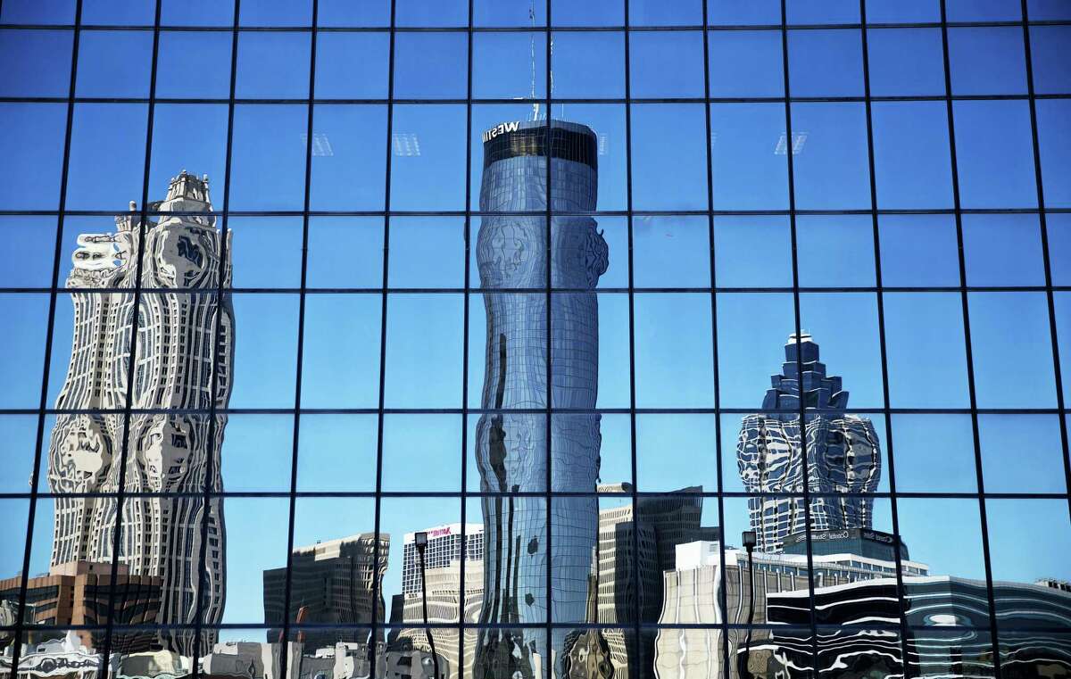 The Westin hotel, center, is reflected along with other downtown buildings in the windows of an office tower in Atlanta, Wednesday, Sept. 28, 2016. An exit button inside the Westin hotel where a worker was found dead failed to work during an inspection, trapping multiple people who had to beat on the door to alert someone to let them out, a medical examiner found. The Fulton County Medical Examiner’s Office has amended its autopsy for Carolyn Mangham to include the new details about the freezer exit button at the Westin Peachtree Plaza.