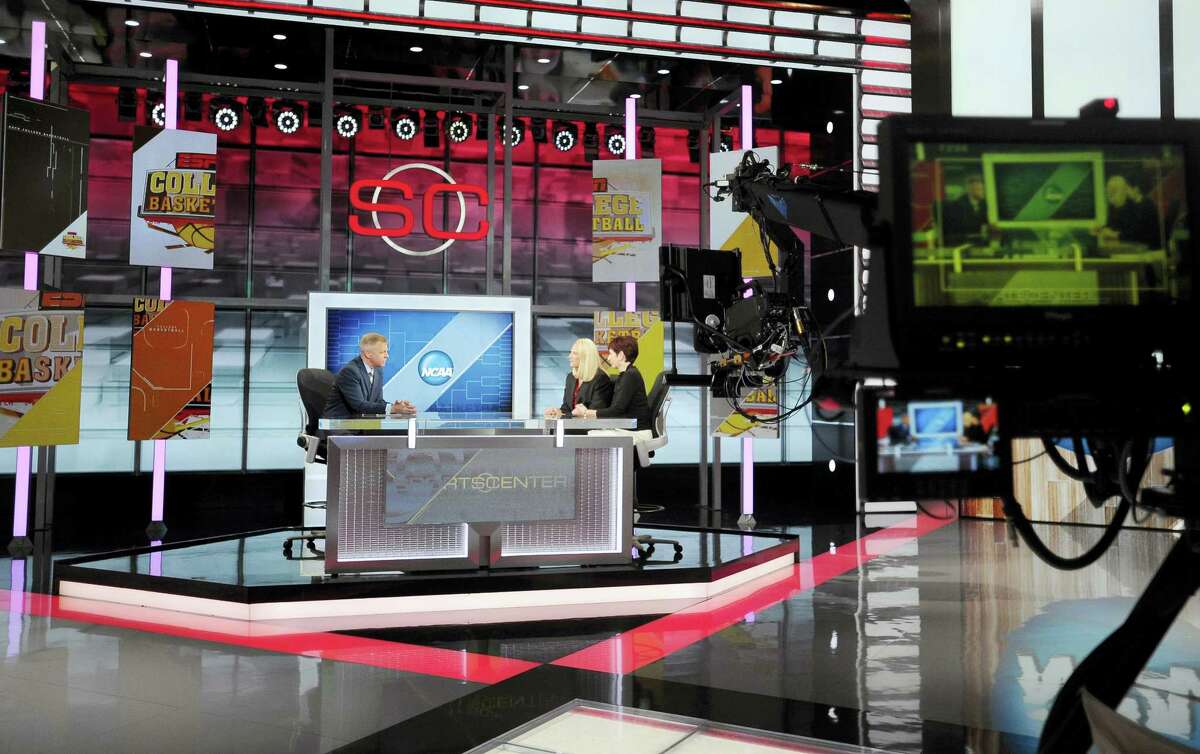 In this Nov. 3, 2015 photo, Notre Dame head coach Muffet McGraw, right, sits with Maryland head coach Brenda Frese for a live interview with sportscaster David Lloyd, left, on SportsCenter at ESPN in Bristol, Conn.