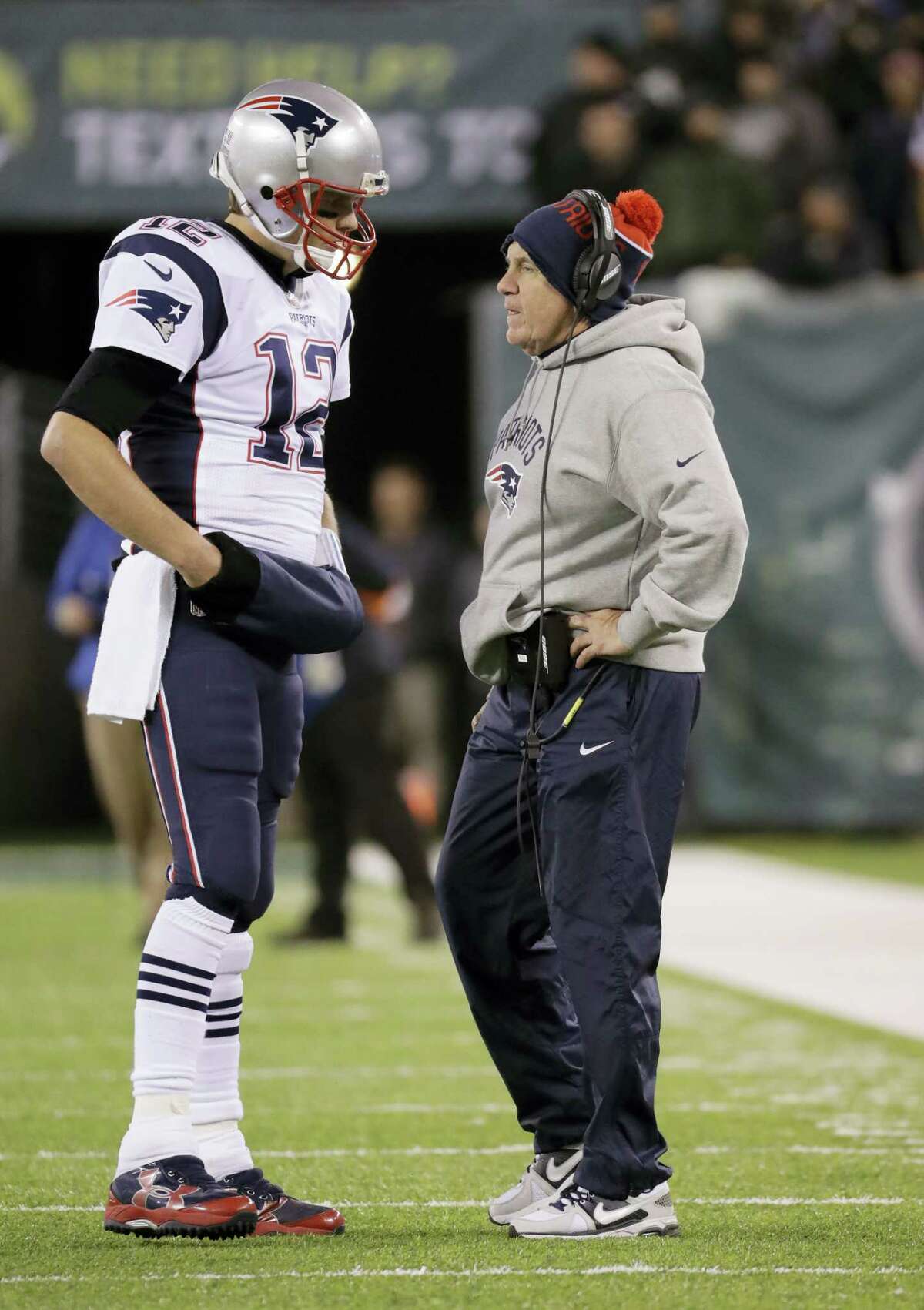 New England Patriots quarterback Tom Brady (12) talks with head coach Bill Belichick.