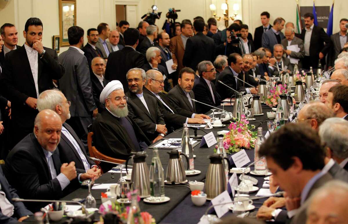 Iranian President Hassan Rouhani, third left seated, attends a meeting with French Economy Minister Emmanuel Macron and French business leaders in Paris, Wednesday, Jan. 27, 2016. Rouhani says his first visit to Europe since the nuclear accord was signed has proven that there are “great possibilities” for economic, academic, scientific and cultural cooperation and that “today we are in a win-win situation” after years of mutual losses due to sanctions.