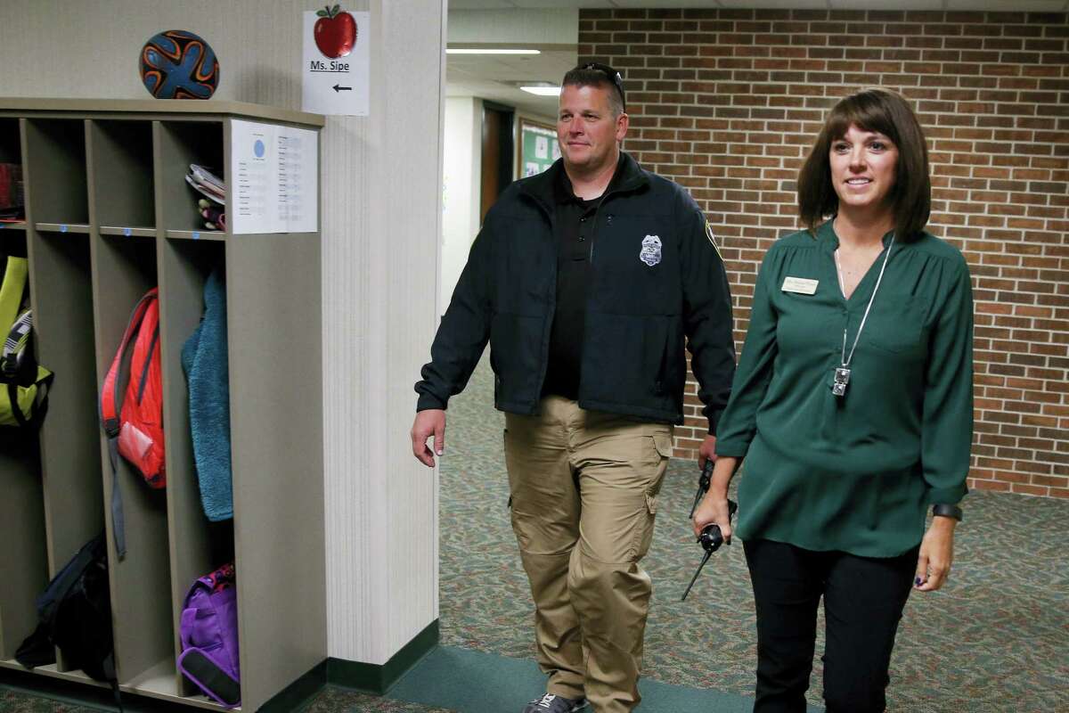In this May 6, 2016, Forest Dale Elementary School principal Deanna Pitman, right, and Carmel, Ind., police officer Greg DeWald walk the halls of the school during an intruder drill at the school in Carmel, Ind. Pitman posed as an intruder for the drill. More and more, schools these days are conducting active-shooter drills. A government report found that more than two-thirds of the school districts surveyed conduct active shooter exercises.