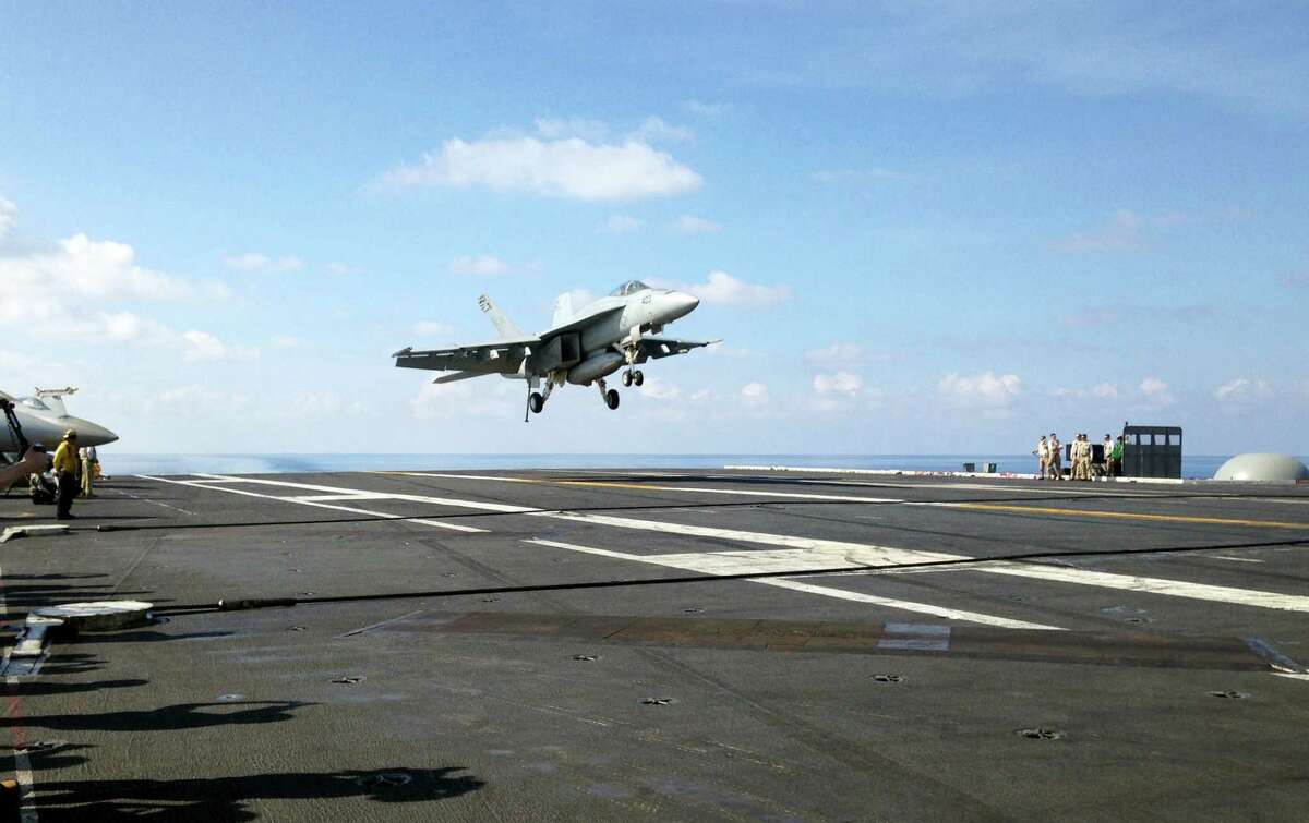 In this Friday, April 15, 2016, file photo, an FA-18 jet fighter lands on the USS John C. Stennis aircraft carrier in the South China Sea while U.S. Defense Secretary Ash Carter visited the aircraft carrier during a trip to the region. (AP Photo/Lolita C. Baldor, File)