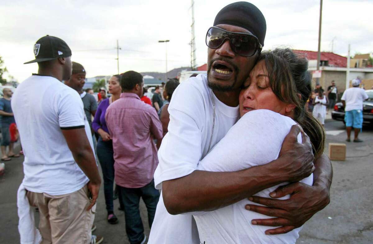 Shawn Letchaw hugs a woman named Marie, who didn’t give her last name, at the scene where a black man was shot by police earlier in El Cajon, east of San Diego, Calif., Tuesday, Sept. 27, 2016. (Hayne Palmour IV/The San Diego Union-Tribune via AP)