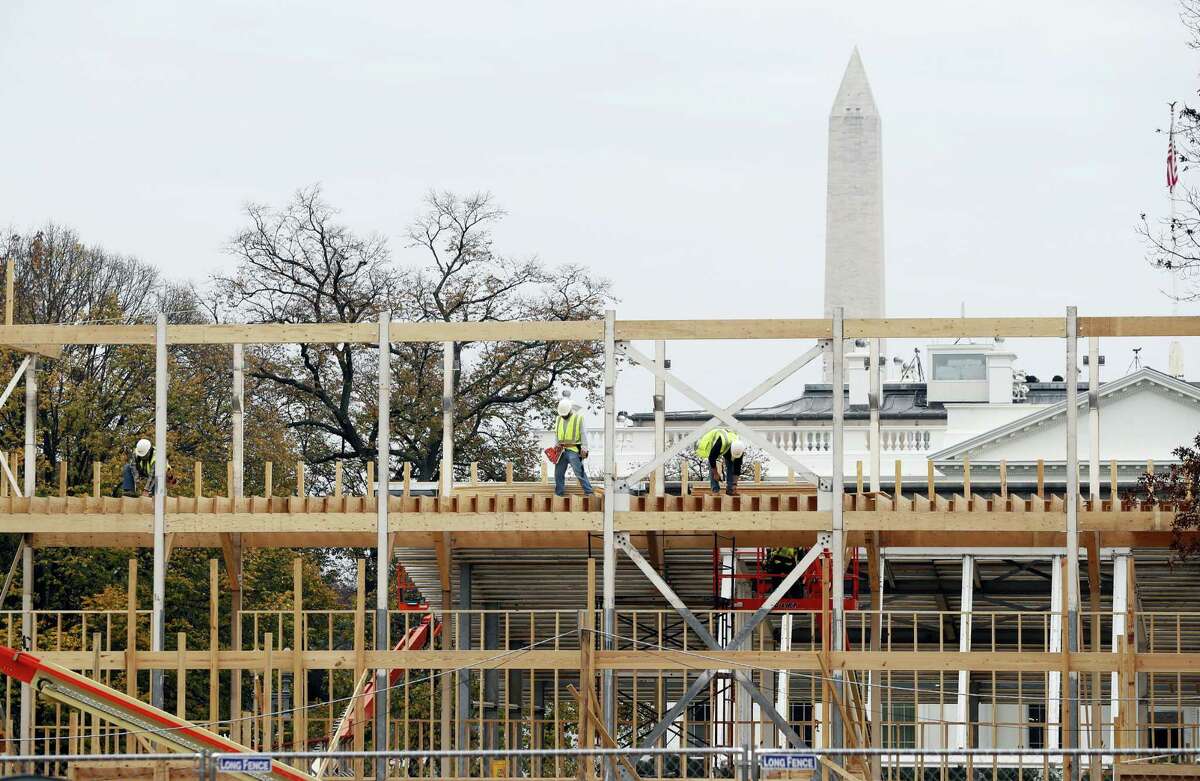 Construction continues on the presidential reviewing stand on Pennsylvania Avenue in Washington, Friday looking toward the White House and the Washington Monument. The reviewing stand is where then President Donald Trump will view the inaugural parade on.