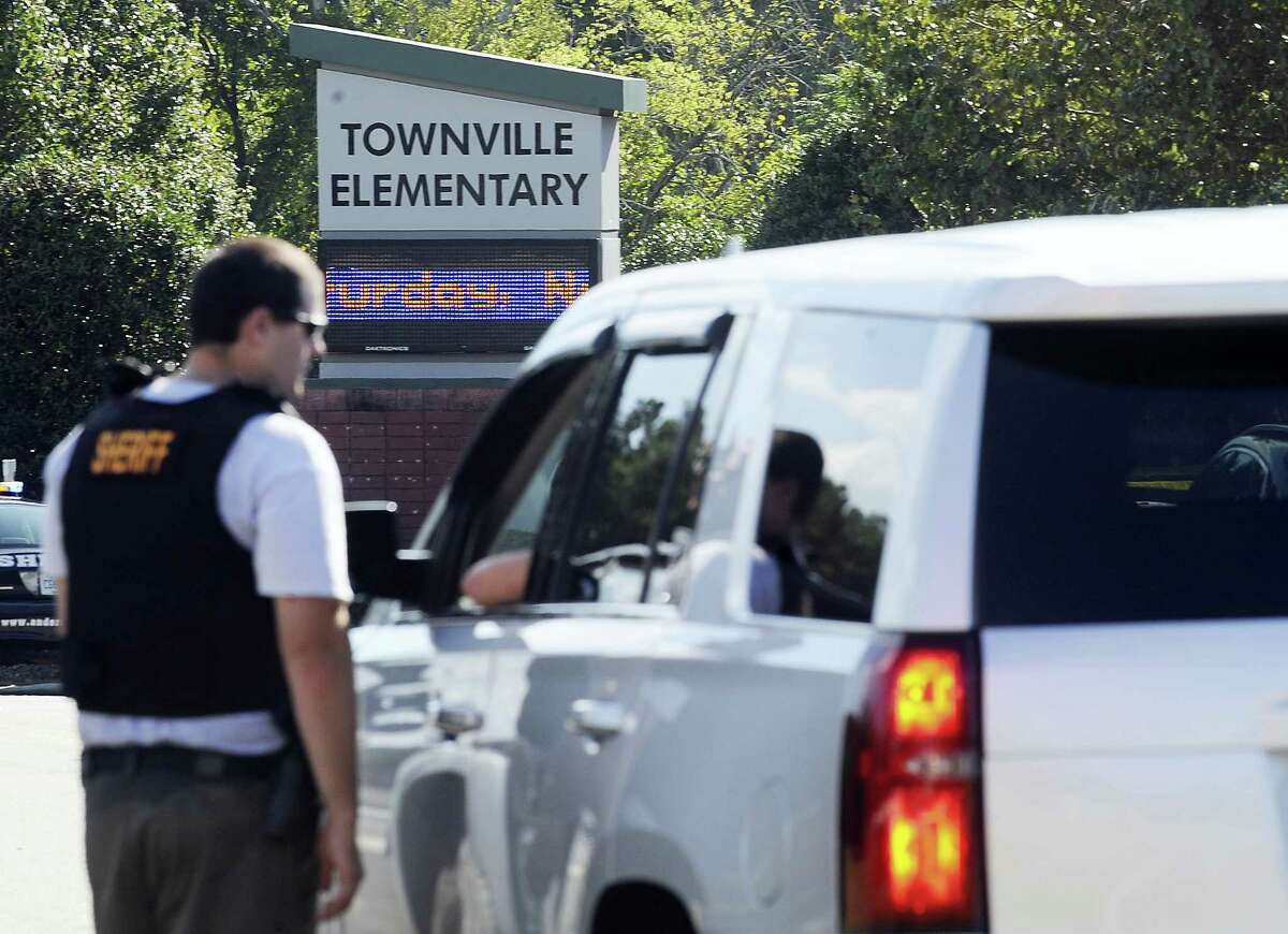 Members of law enforcement talk in front of Townville Elementary School on Wednesday, Sept. 28, 2016, in Townville, S.C. A teenager opened fire at the South Carolina elementary school Wednesday, wounding two students and a teacher before the suspect was taken into custody, authorities said.
