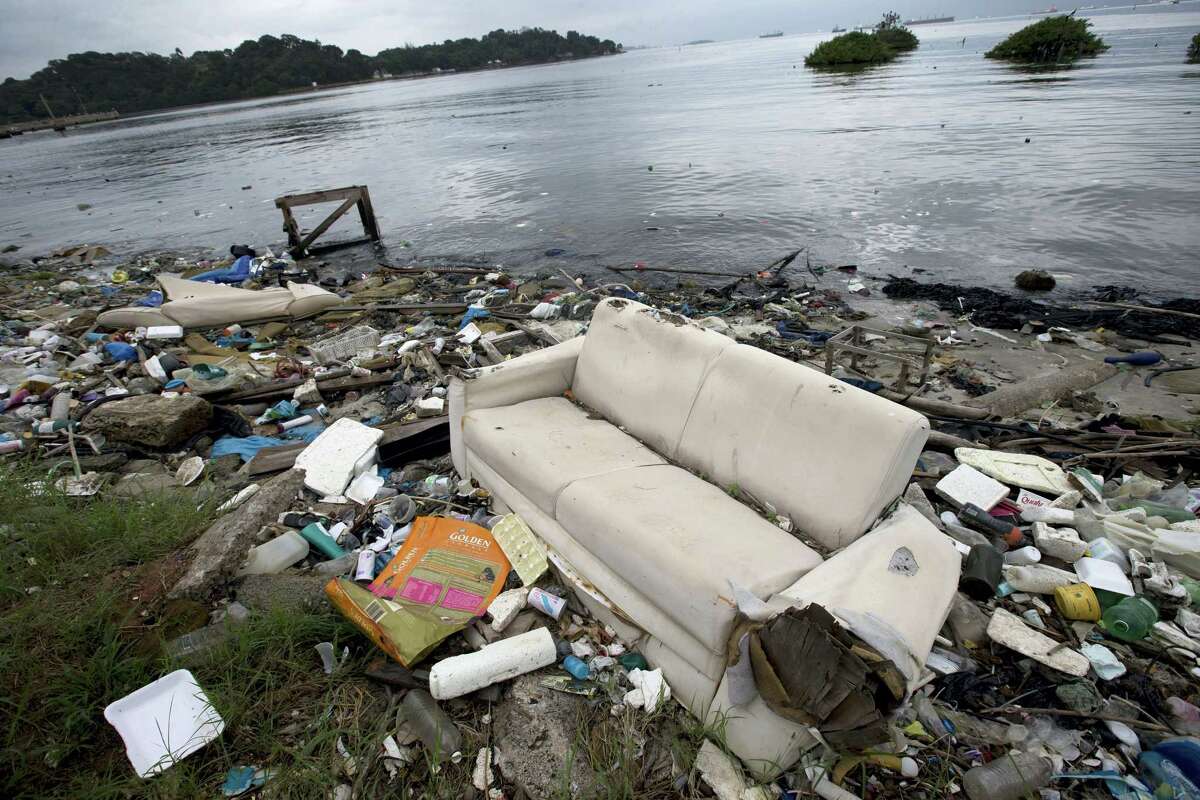 In this June 1, 2015 file photo, a discarded sofa litters the shore of Guanabara Bay in Rio de Janeiro, Brazil. About 1,600 athletes will compete in Rio during the 2016 Summer Olympics. Hundreds more will be involved during the subsequent Paralympics. Experts say athletes will be competing in the viral equivalent of raw sewage with exposure to dangerous health risks almost certain. Many sailors have described the conditions as “sailing in a toilet” or an “open sewer.”