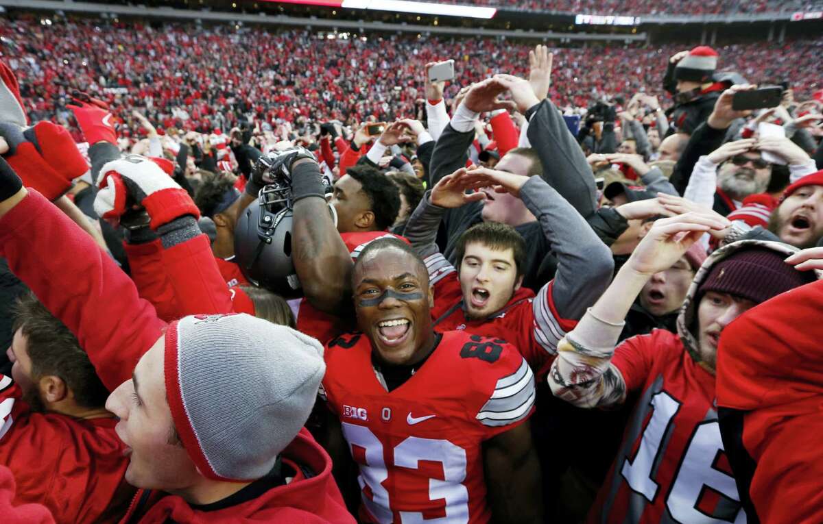 Ohio State players and fans celebrate their win over Michigan on Saturday.