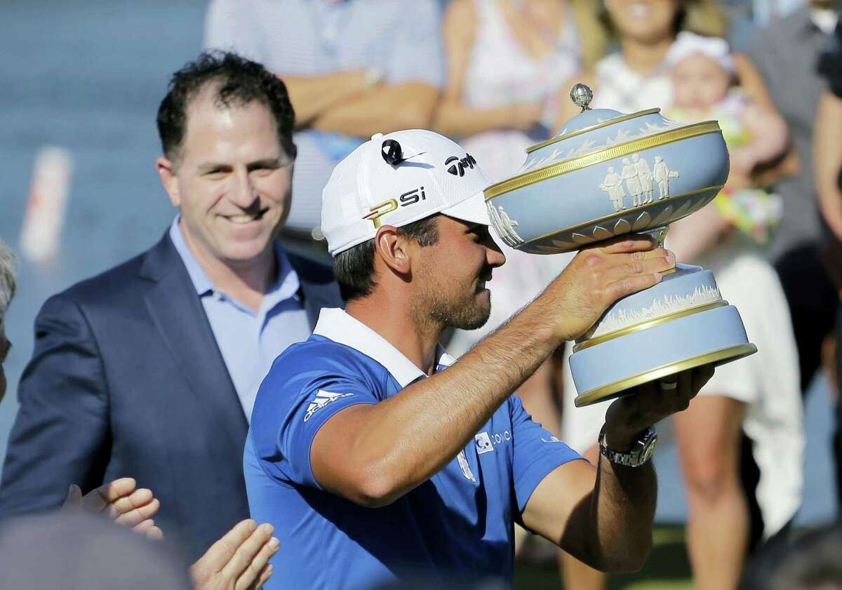 Jason Day holds his trophy after defeating Louis Oosthuizen in the final round the Dell Match Play Championship golf tournament at Austin County Club, Sunday. Dell CEO Michael Dell, left, made the presentation.