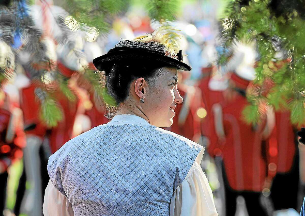 Oliva Delaney of the Comwell Historical Society listens to the Comwell Memorial Day ceremony before the annual parade on the green at Veterans Park in a previous year.