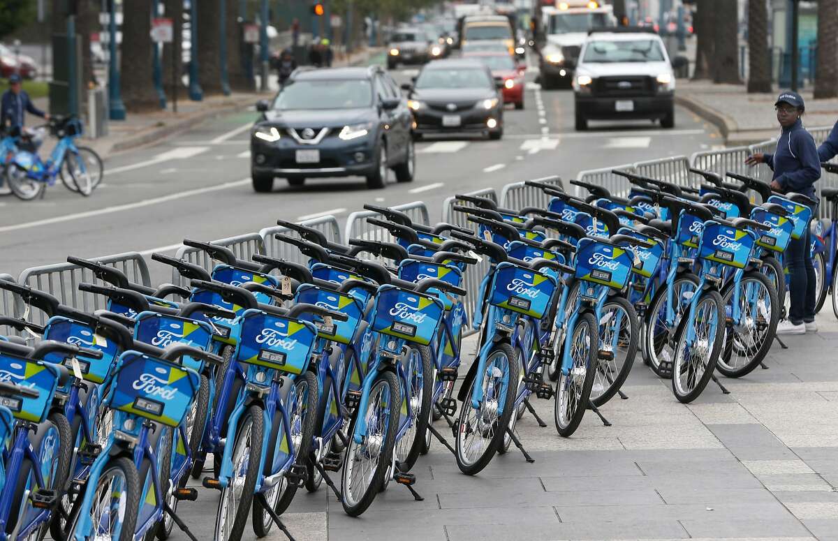 Kara Awakoaiye (right) organizes a fleet of Ford GoBike bicycles in front of the Ferry Building in San Francisco, Calif. on Wednesday, June 28, 2017. The Bay Area-wide bike sharing service, which plans a fleet of 3,500 bicycles by Labor Day and as many as 7,000 by the end of 2018, went into service today.