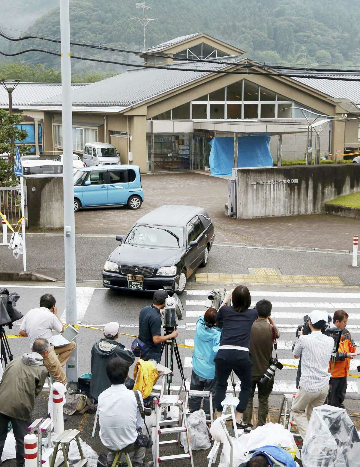 A hearse leaves the Tsukui Yamayuri-en, a facility for the mentally disabled where a number of people were killed and dozens injured in a knife attack Tuesday, July 26, 2016, in Sagamihara, outside Tokyo. A young Japanese man went on a stabbing rampage early Tuesday at the facility where he had been fired, officials said, killing many people months after he gave a letter to Parliament outlining the bloody plan and saying all disabled people should be put to death.