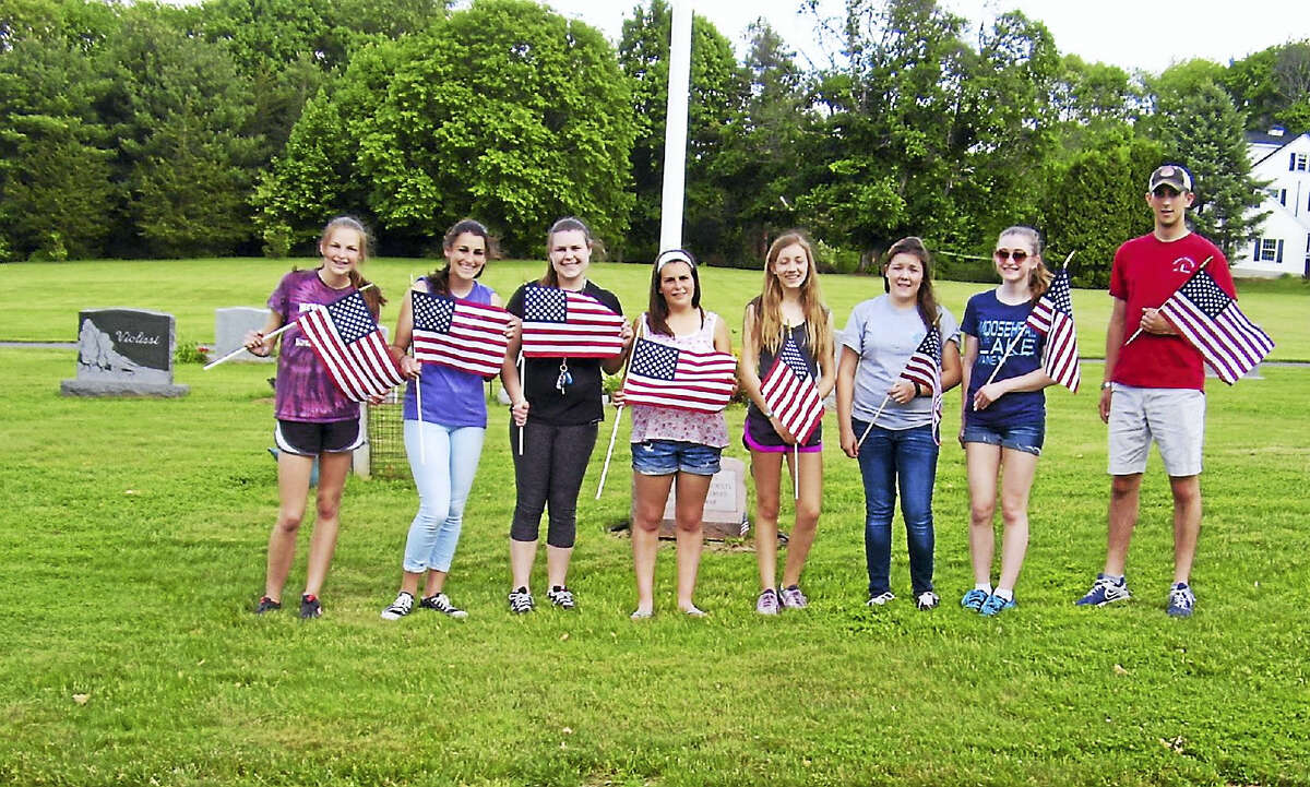 Portland High School students placed flags at the veterans graves in cemeteries throughout town earlier this week. Shown are, from left, Ashley Benham, Sarah Donahue, Morgan Benham, Katherine Donahue, Gracie Berthiaume, Alicia, Archuleta, Rebecca Tripp and Andrew Donahue, who is on leave from the USMA.