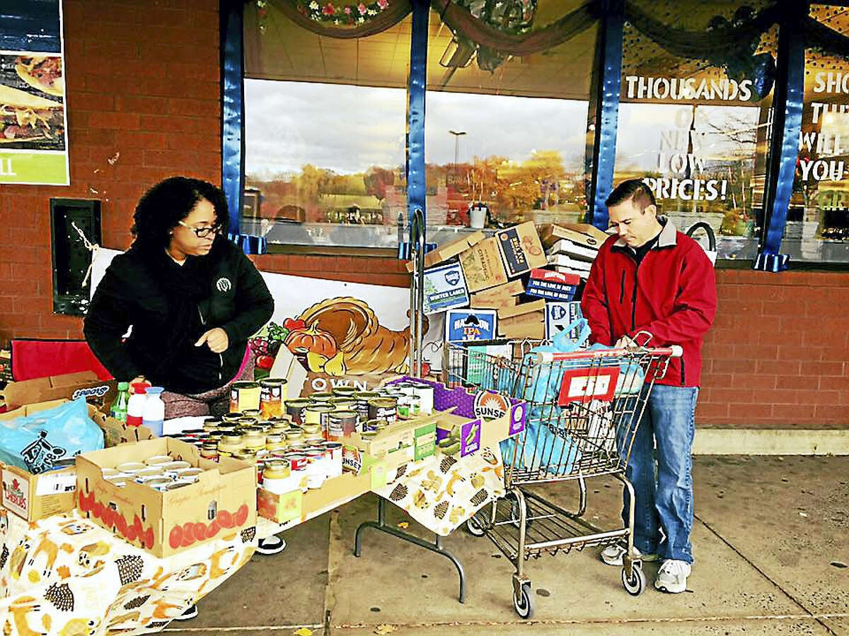 This year, more than 950 baskets of food were assembled by volunteers working in conjunction with the Middlesex United Way for the Middletown Community Thanksgiving Project. Here, canned goods are collected at Stop & Shop on East Main Street in Middletown last week.