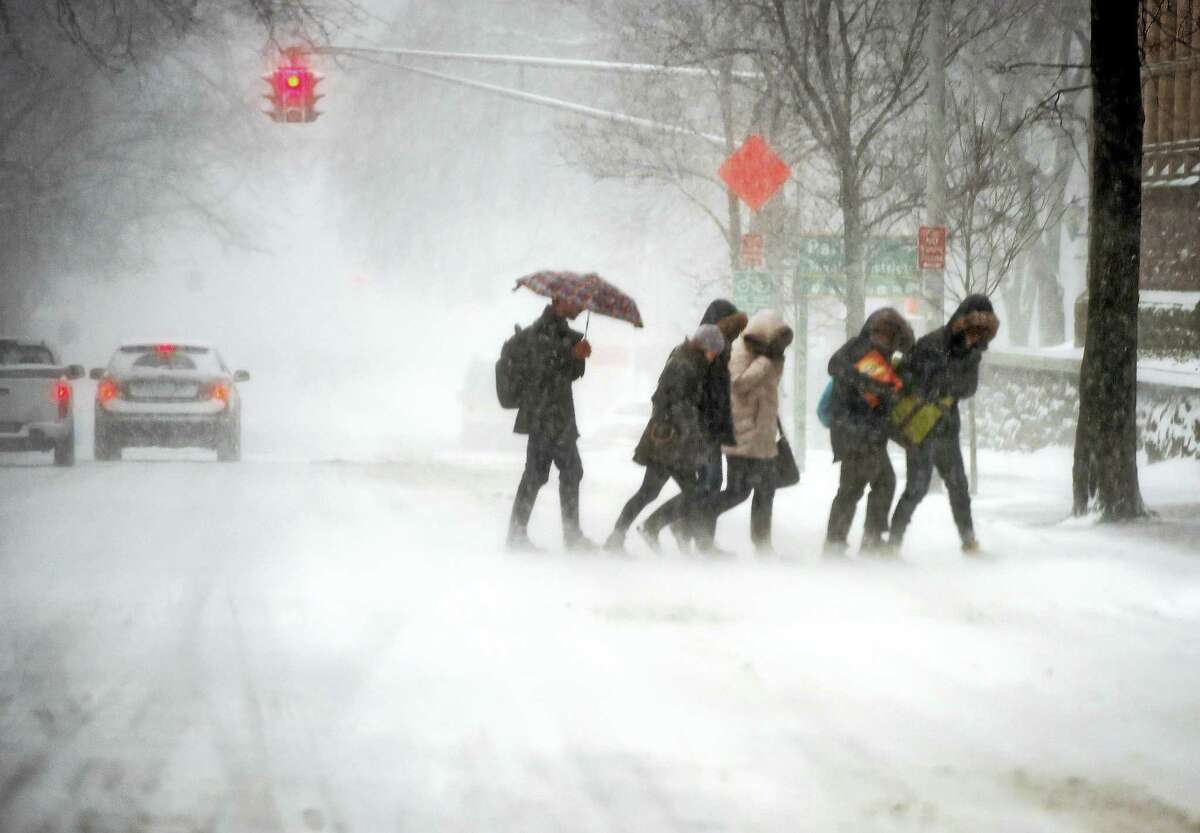 (Arnold Gold-New Haven Register) A group of pedestrians cross Elm St. in New Haven during a snow storm on 1/23/2016.