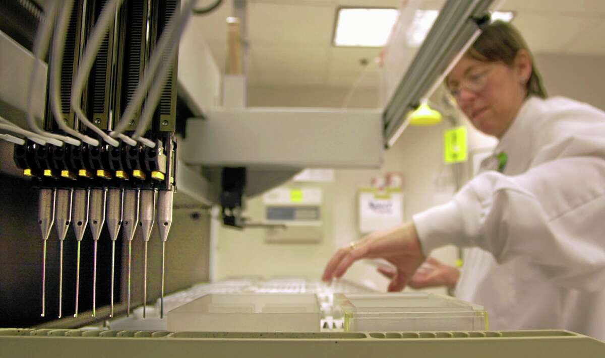 A technician loads samples into a machine for testing at Myriad Genetics in Salt Lake City.