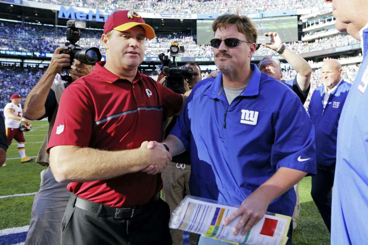 Washington head coach Jay Gruden, left, and Giants head coach Ben McAdoo, right, shake hands after Sunday’s game.