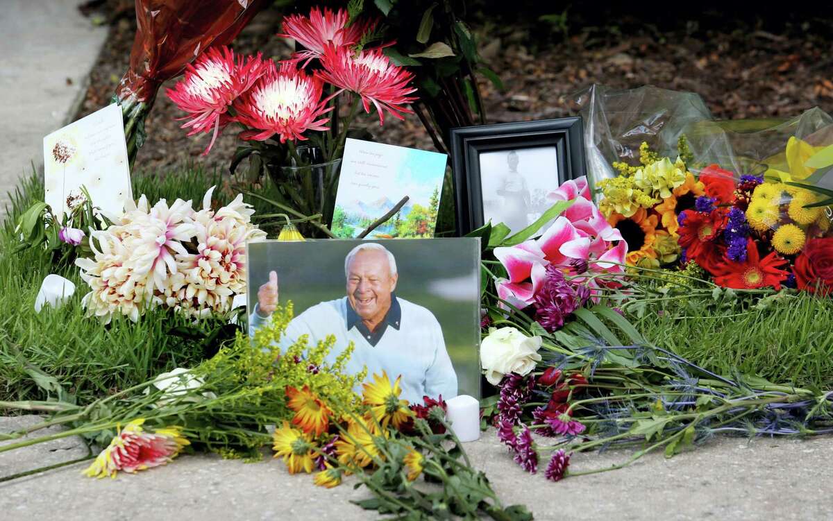 Flowers and mementos adorn a makeshift memorial honoring the late golf great Arnold Palmer at Palmer’s parking spot at the Golf Channel studios in Orlando, Fla., Monday.