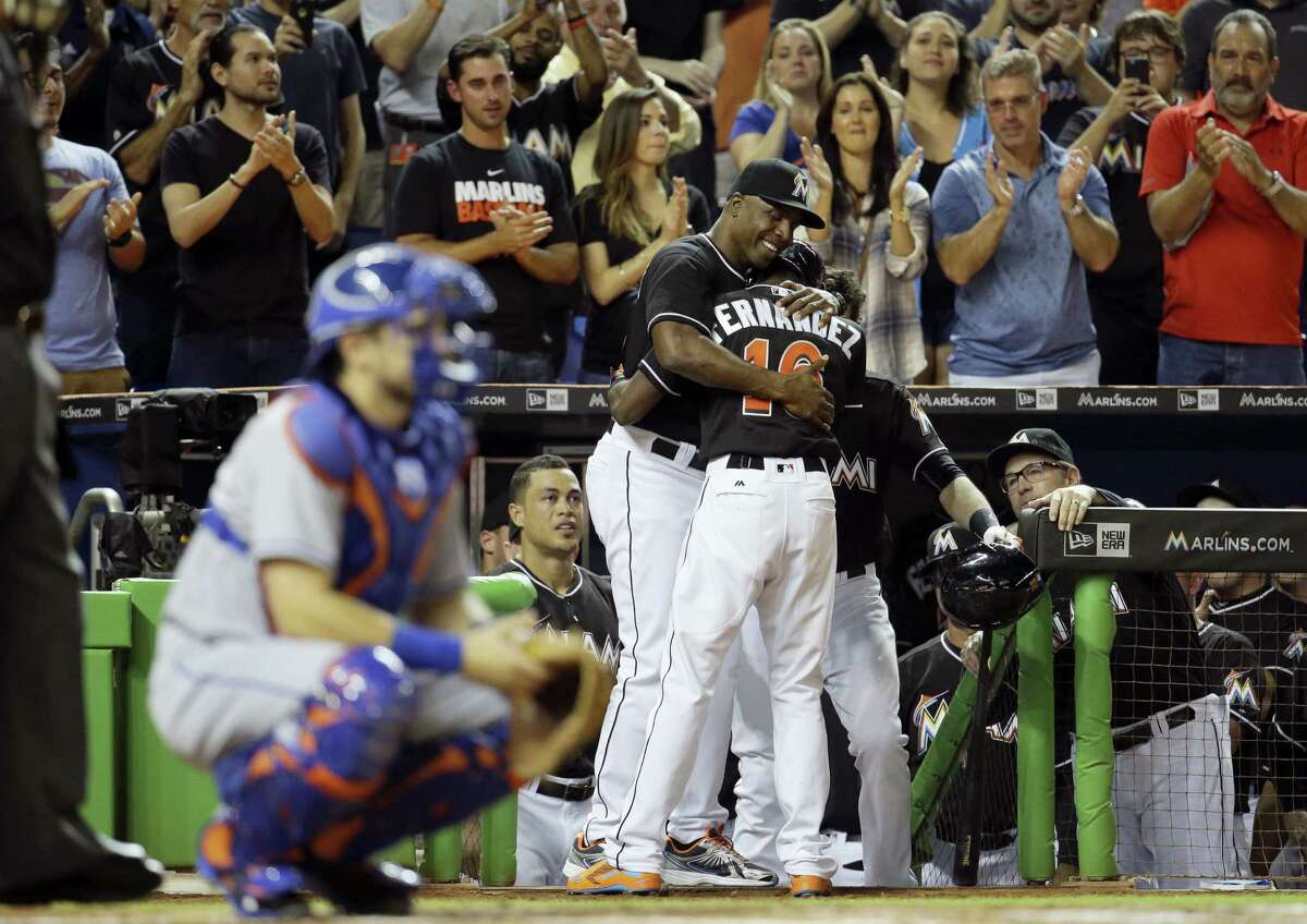 Marlins hitting coach Barry Bonds, left, hugs Dee Gordon, right, after he hit a solo home run in his first at-bat.