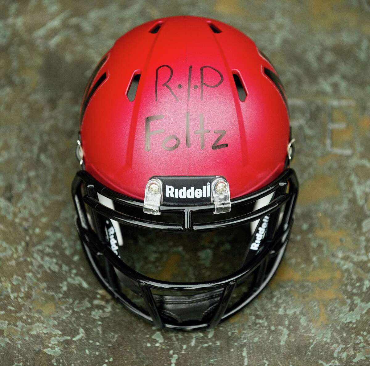 A Nebraska mini-football helmet inscribed “RIP Foltz,” for Nebraska punter Sam Foltz is seen during a vigil for Foltz, Sunday in Lincoln, Neb. Foltz and former Michigan State punter Mike Sadler died in a car crash in Wisconsin after working at a kicking clinic.