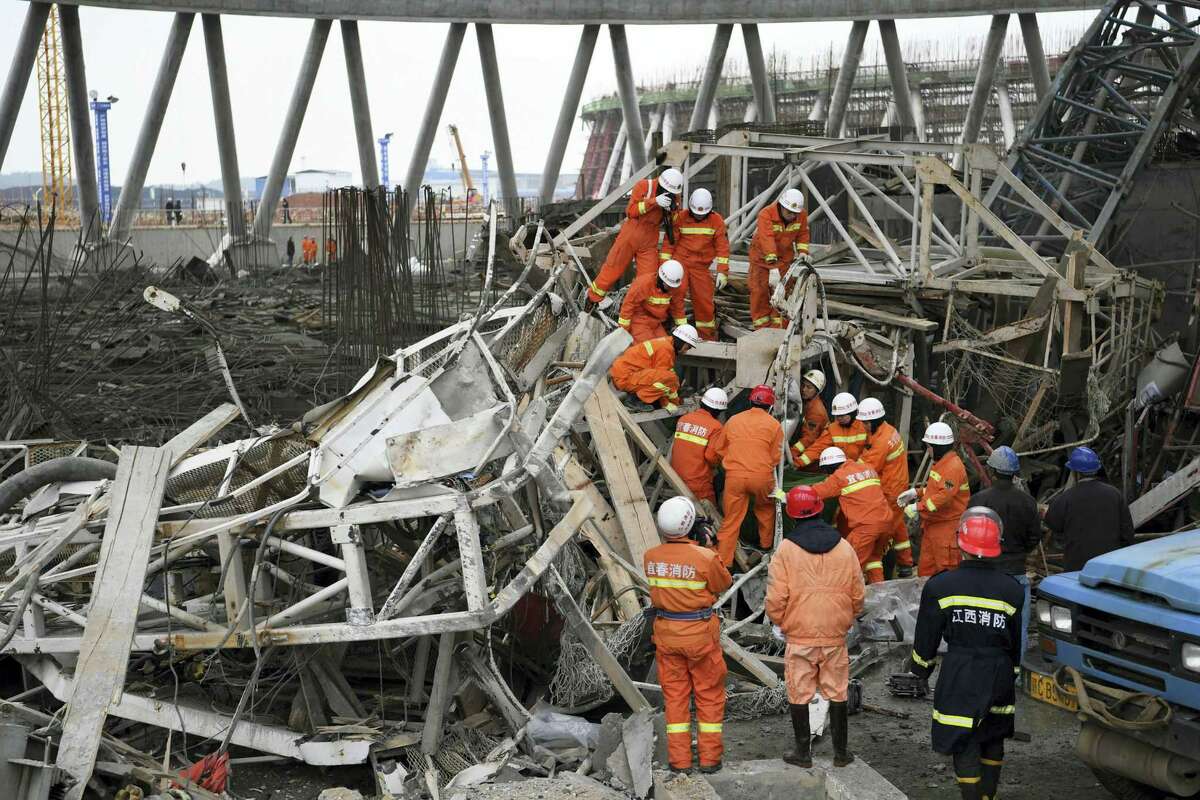 In this photo released by Xinhua News Agency, rescue workers look for survivors after a work platform collapsed at the Fengcheng power plant in eastern China’s Jiangxi Province, Nov. 24, 2016. State media reported dozens were killed after the scaffolding tumbled down.