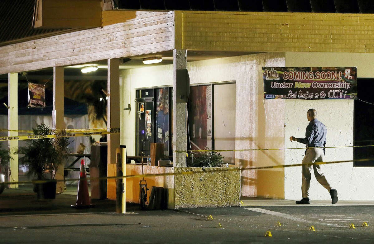 An investigator walks near the scene of a fatal shooting at Club Blu nightclub in Fort Myers, Fla. on July 25, 2016.