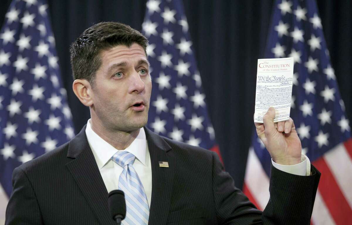 House Speaker Paul Ryan holds a copy of the Constitution as he decries ugliness and divisiveness in American politics, delivering a veiled but passionate rebuke to GOP presidential front-runner Donald Trump and the nasty tone of the presidential campaign as he addressed congressional interns Wednesday on Capitol Hill in Washington.