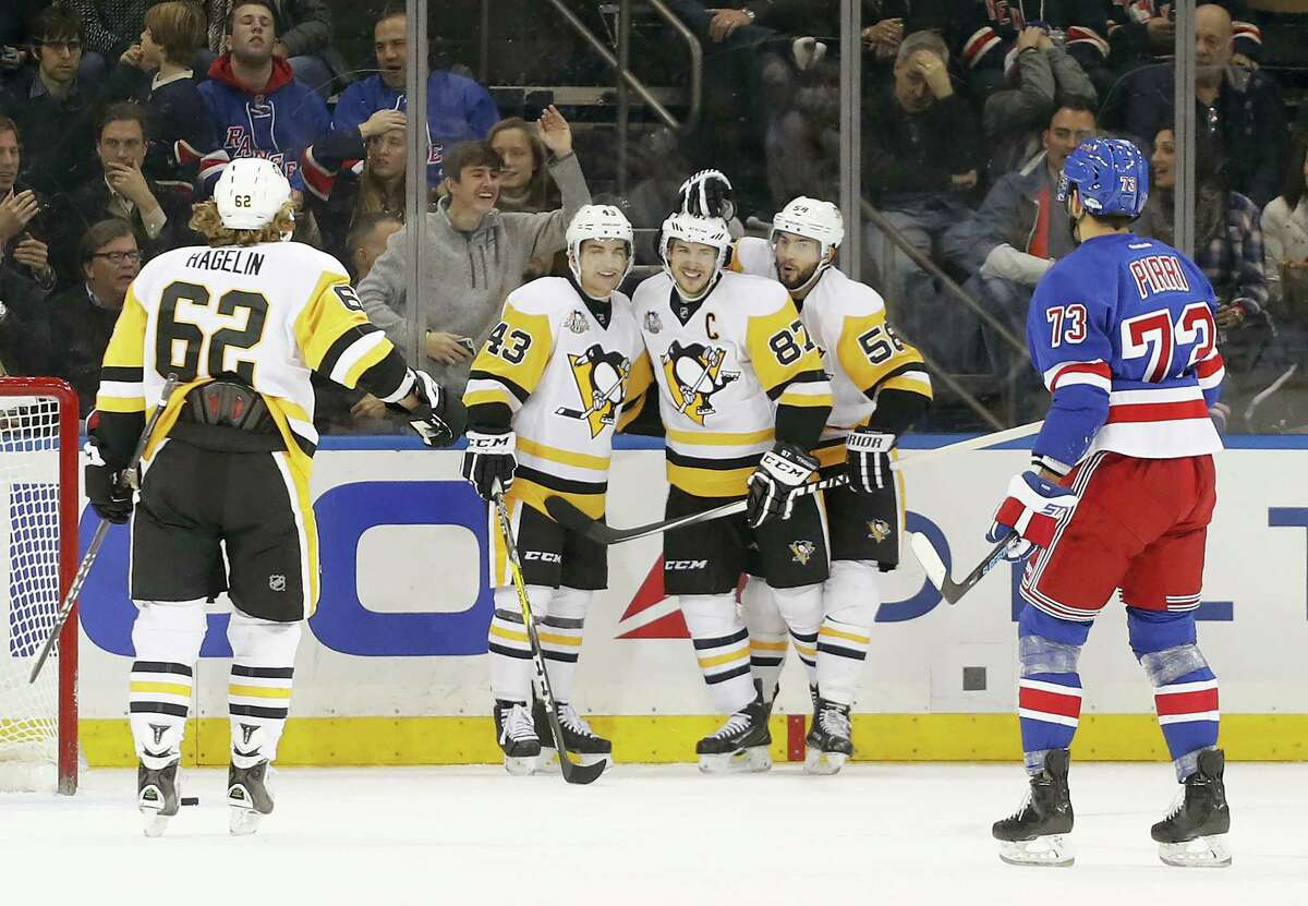 Pittsburgh Penguins center Sidney Crosby (87) is congratulated by teammates after scoring a goal against the New York Rangers during the second period of an NHL hockey game, Wednesday in New York.