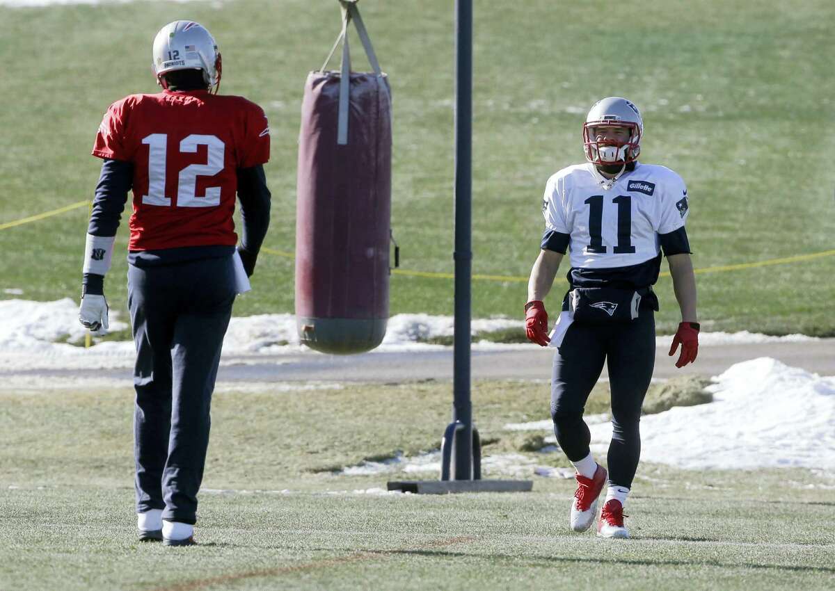 Patriots quarterback Tom Brady (12) and wide receiver Julian Edelman (11) warm up during practice on Thursday.