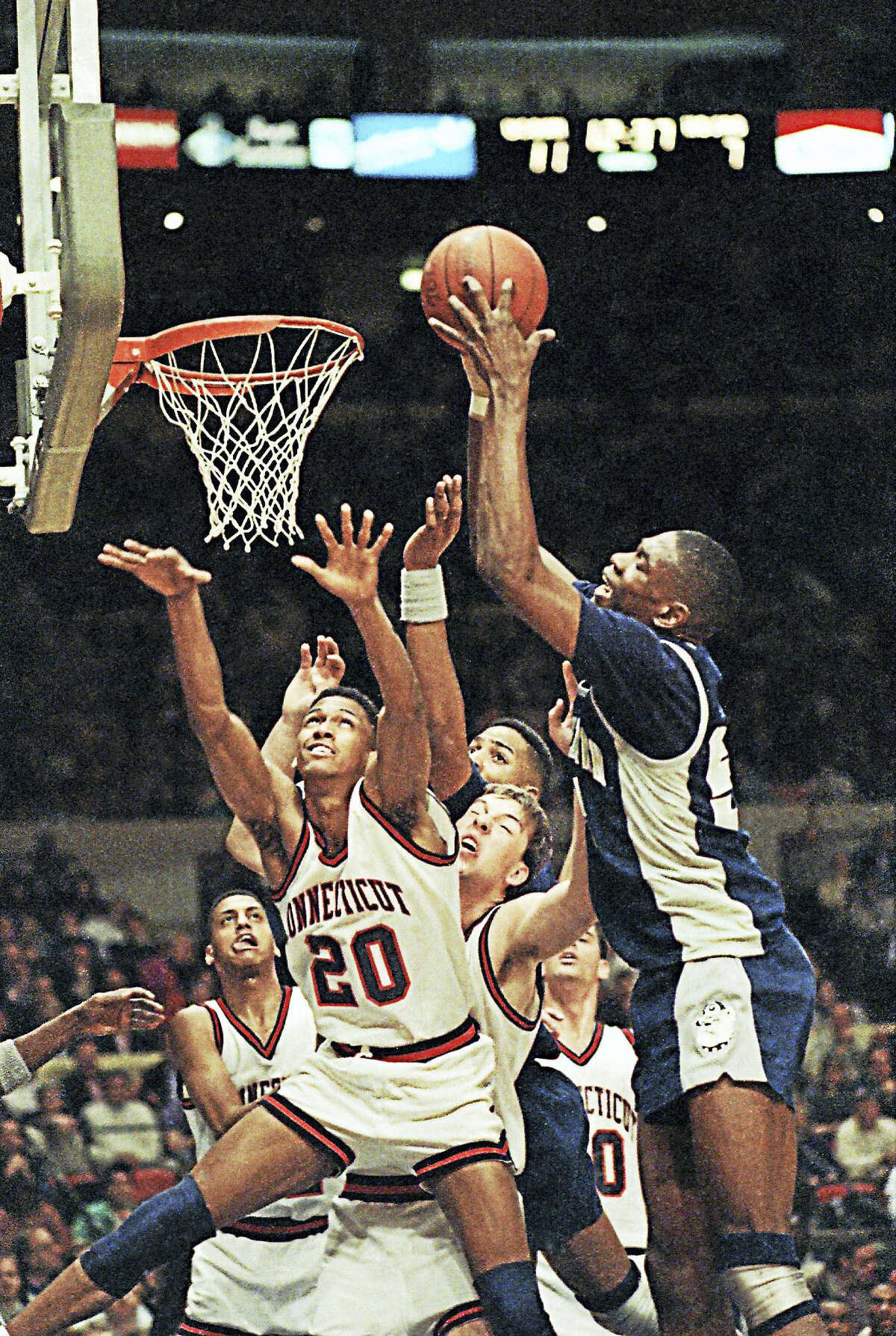 UConn’s Murray Williams (20) tries in vain to thwart the shot of Georgetown’s Dikembe Mutombo during te Big East tournament in New York on March 10, 1990. The Huskies won that game 65-60.