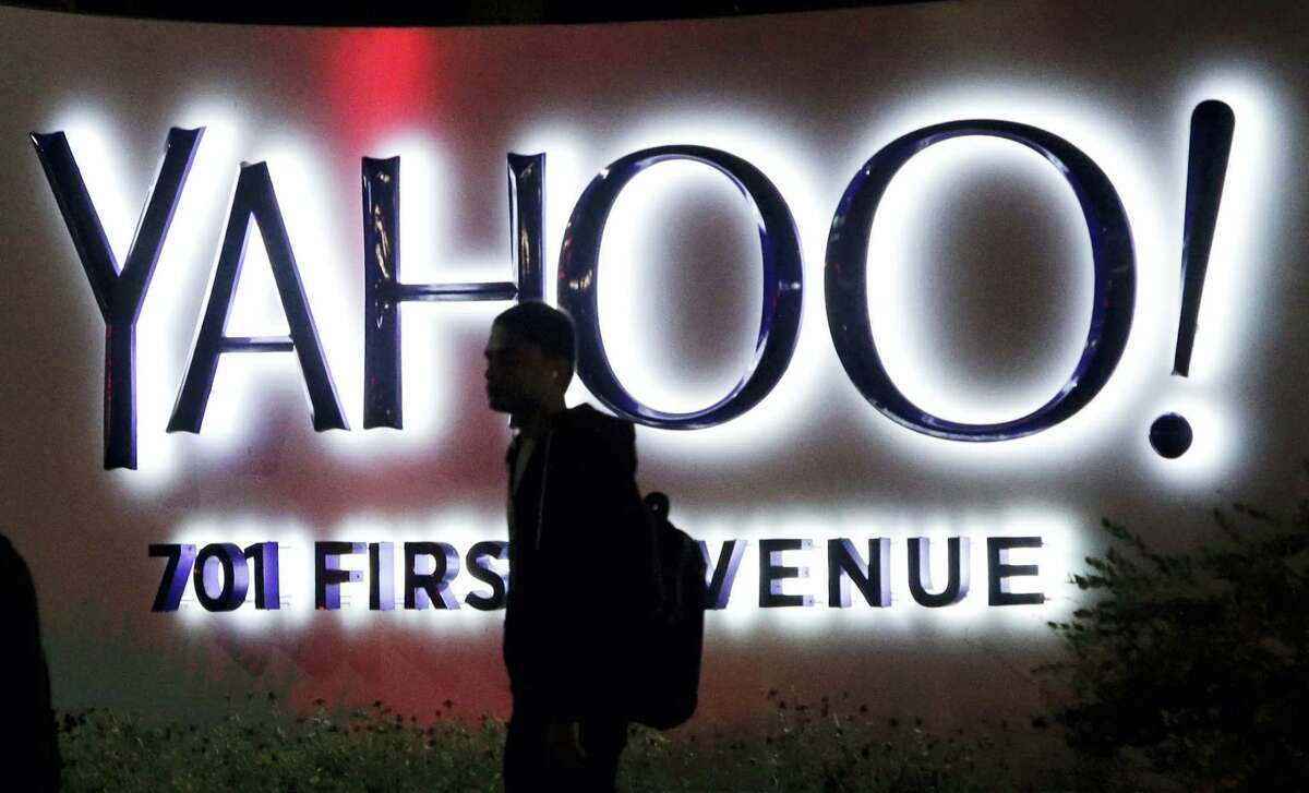 In this Nov. 5, 2014 photo, a person walks in front of a Yahoo sign at the company’s headquarters in Sunnyvale, Calif.