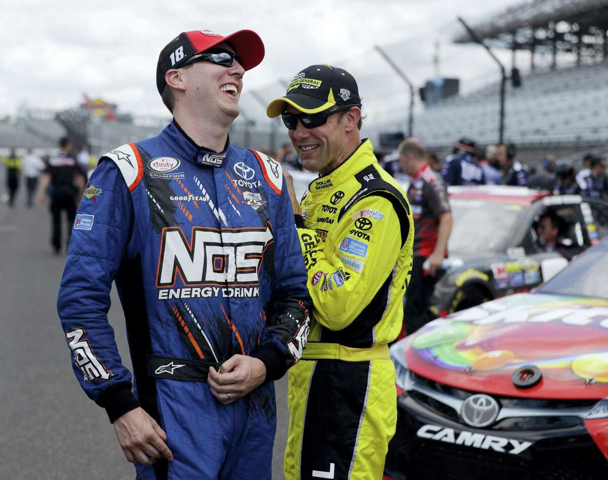 Sprint Cup Series driver Kyle Busch (18) laughs with driver Matt Kenseth (20) before qualifications for the Brickyard 400 NASCAR auto race at Indianapolis Motor Speedway in Indianapolis, Saturday.