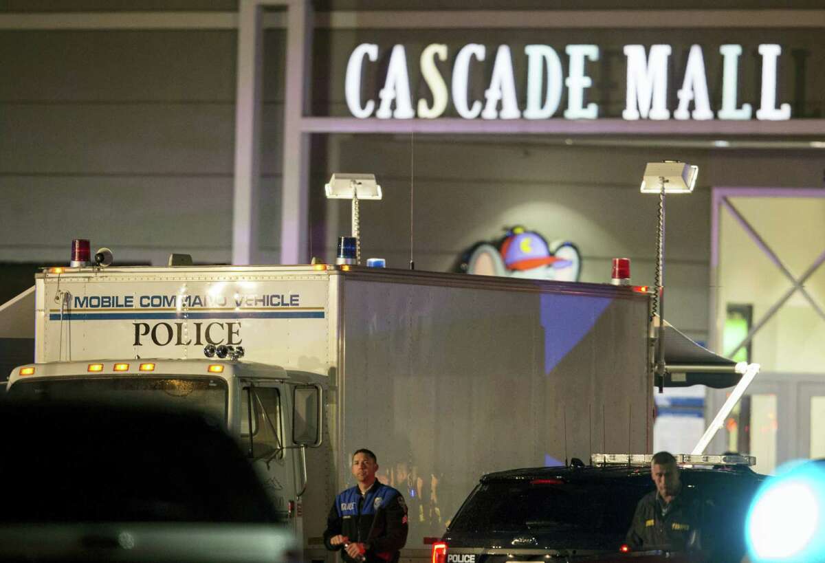 Law enforcement officers stand near a mobile police command center at the scene of a shooting where several people were killed Friday, Sept. 23, 2016, in Burlington, Wash. Police searched Saturday for a gunman who opened fire in the makeup department of a Macy’s store at the mall north of Seattle, killing several females, before fleeing toward an interstate on foot, authorities said.