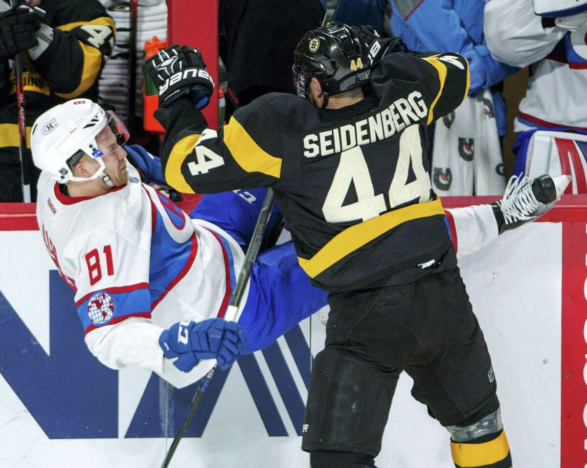 Montreal Canadiens center Lars Eller (81) is knocked off his skates by Boston Bruins defenseman Dennis Seidenberg (44) during the second period of an NHL hockey game Tuesday, Jan. 19, 2016, in Montreal. (Ryan Remiorz/The Canadian Press via AP)