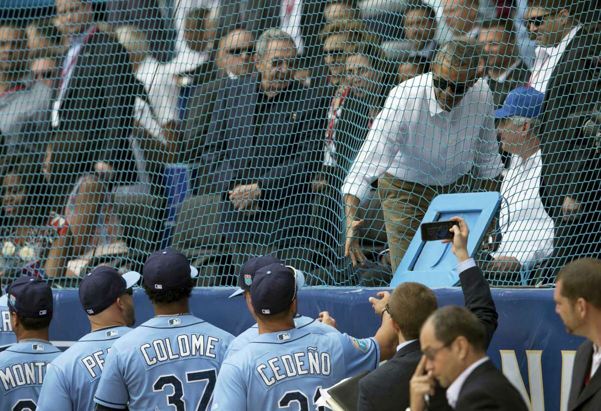 Cuban President Raul Castro, center left, looks on as U.S. President Barack Obama greets the Tampa Bay Rays players before their game on Tuesday.