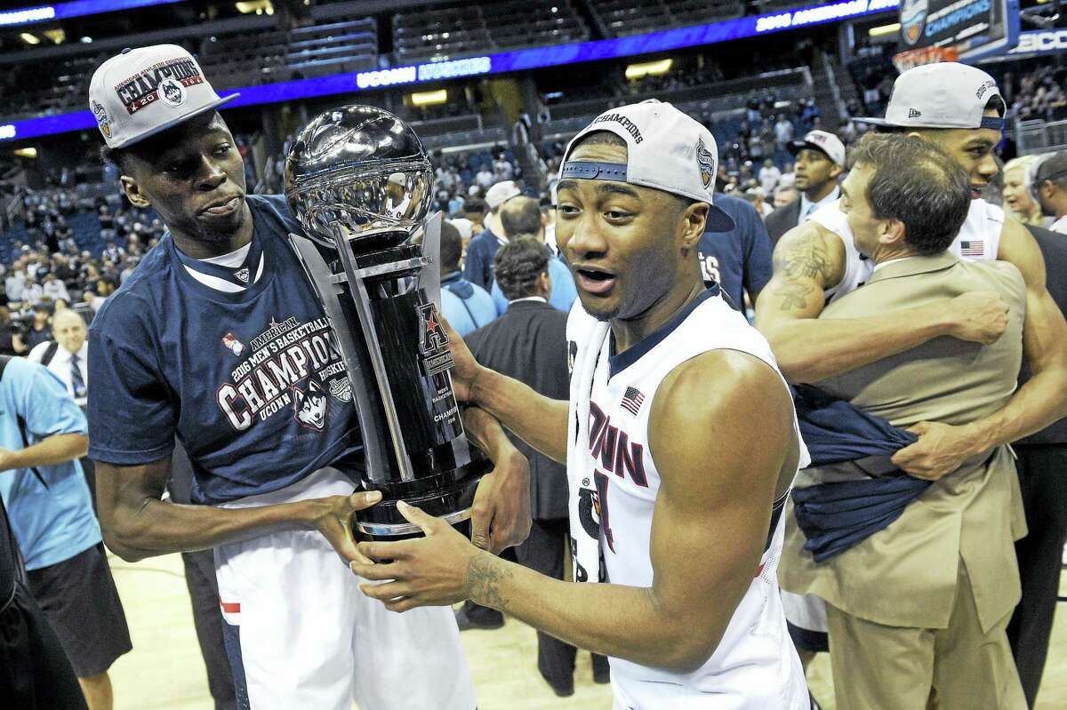 UConn center Amida Brimah, left, and guard Rodney Purvis (44) celebrate with the championship trophy in the finals of the American Athletic Conference men’s tournament this past March.