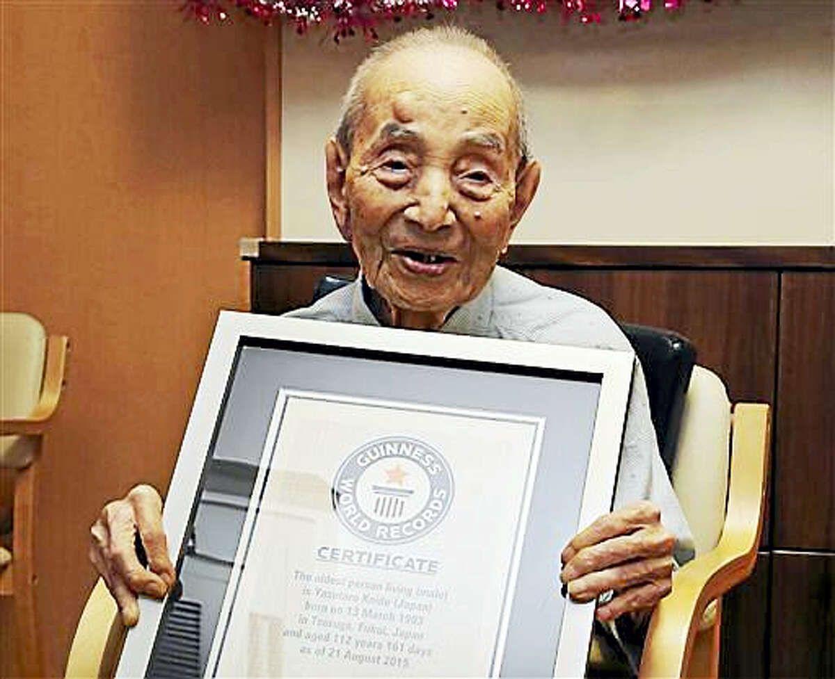 In this Aug. 21, 2015, file photo, Yasutaro Koide, 112, holds the Guinness World Records certificate as he is formally recognized as the world’s oldest man at a nursing home in Nagoya, central Japan. Koide, who was born on March 13, 1903, has died on Tuesday, Jan. 19, 2016, two months short of his 113th birthday.