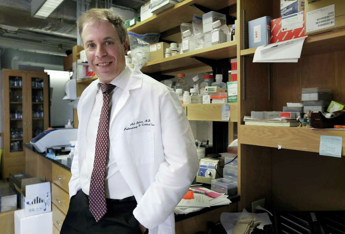 In this March 17, 2016 photo, Boston University professor Avi Spira, a medical researcher in chronic obstructive pulmonary disease, stands for a portrait in his lab at Boston University School of Medicine in Boston. Johnson & Johnson’s ambitious project to find ways to prevent diseases or stop them early on has been expanding rapidly and now includes about two dozen collaborations with outside research partners.
