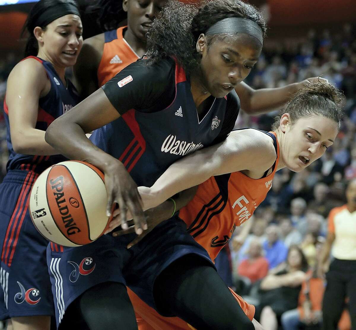 The Sun’s Kelly Faris, right, tries to get the ball from the Mystics’ Kahleah Copper on Saturday.