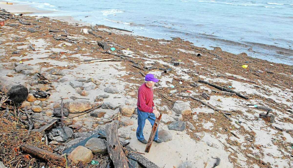 Westbrook resident Nick DeMarco walks along West Beach, which is covered by debris left by Superstorm Sandy, in this 2012 photograph. The recent increase in storm intensity is just one of the topics to be covered in a March 29 talk in Middletown.