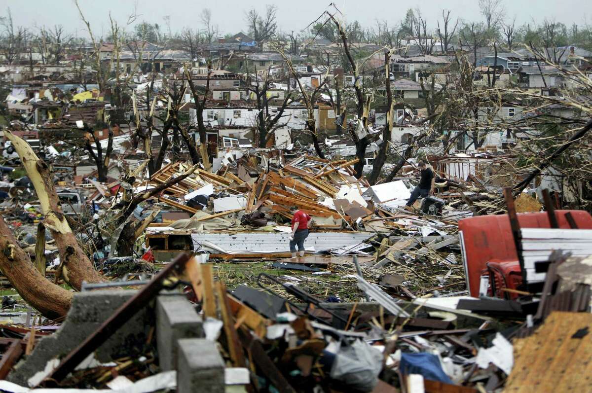 In this May 23, 2011, file photo, Meghan Miller stands in the middle of a destroyed neighborhood as she checks on her sister-in-law’s home in Joplin , Mo. A sky-darkening storm was working its way into southwest Missouri around dinnertime on a Sunday evening of May 22, 2011, zeroing in on the city of Joplin. Forecasters knew the storm’s potential was fierce and gave early warnings. Then, as storm sirens blared, one of the nation’s deadliest tornados hit -- leveling a miles-wide swath of Joplin and leaving 161 people dead.