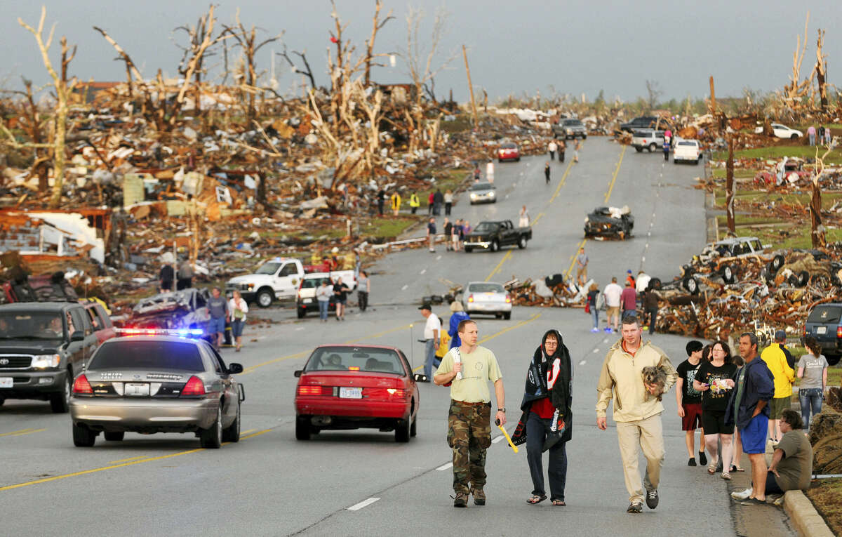 In this May 22, 2011, file photo residents walk in the street after a massive tornado hit Joplin, Mo. A sky-darkening storm was working its way into southwest Missouri around dinnertime on a Sunday evening of May 22, 2011, zeroing in on the city of Joplin. As storm sirens blared, one of the nation’s deadliest tornados hit -- leveling a miles-wide swath of Joplin and leaving 161 people dead.