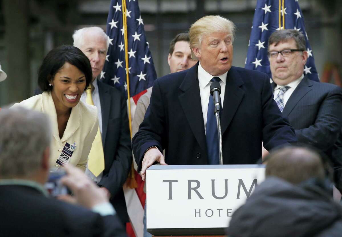 Alicia Watkins of Gaithersburg, Md., left, reacts as she talks to Republican presidential candidate Donald Trump after asking him for a job, while he was speaking during a campaign event in the atrium of the Old Post Office Pavilion, soon to be a Trump International Hotel, Monday in Washington.