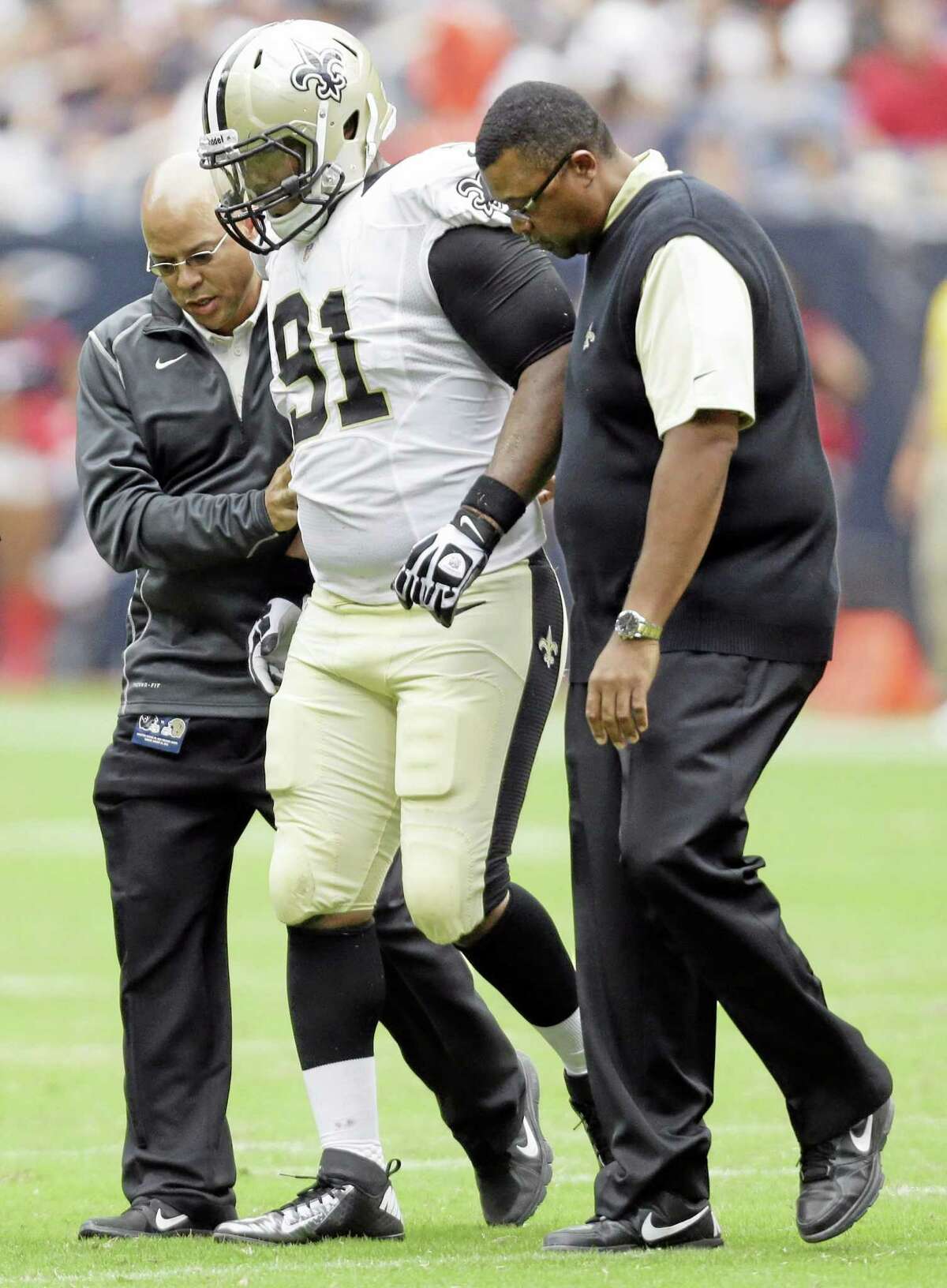 New Orleans Saints linebacker Will Smith (91) is helped off the field during the first half of a preseason NFL football game against the Houston Texans on Aug. 25, 2013, in Houston.
