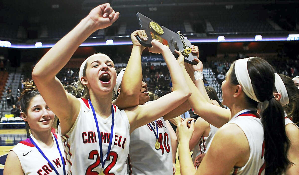 Cromwell senior Araya Lessard (22) raises the Class M state championship plaque after the Panthers’ 43-20 win over Notre Dame-Fairfield.