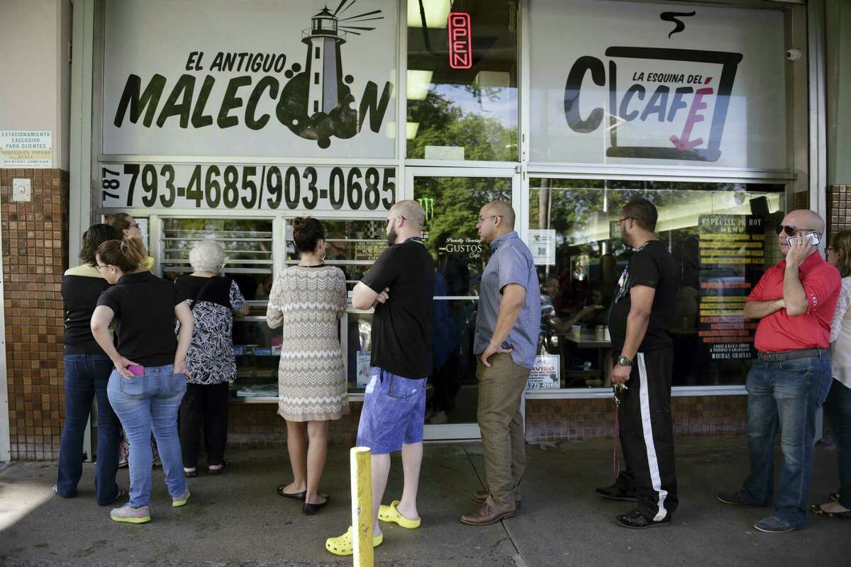 Customers stand in line at one of the few open cafeterias on Roosevelt Avenue, in San Juan, Puerto Rico on Sept. 22, 2016 after a massive blackout hit the island Wednesday afternoon, leaving at least 1.5 million people without power overnight and into the following day.