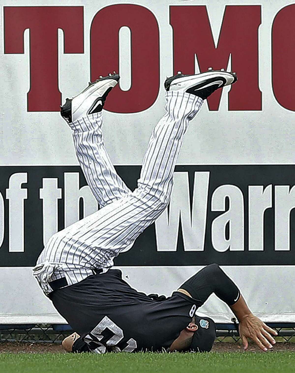 Yankees center fielder Jacoby Ellsbury flips over after making a diving catch on a fly ball by the Braves’ Nick Swisher during the first inning on Saturday.