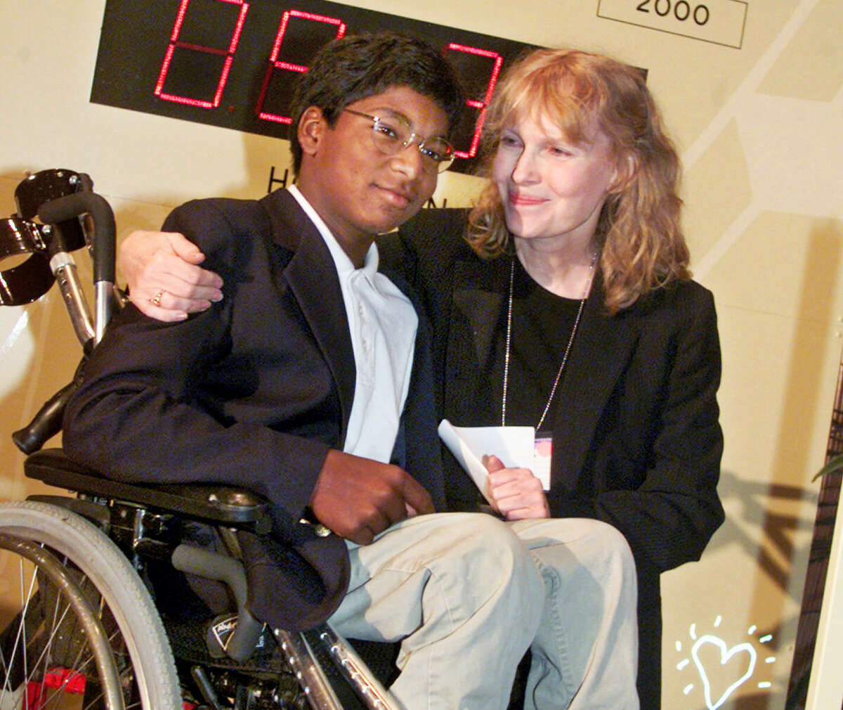 In this Sept. 27, 2000 file photo, actress Mia Farrow poses with her adopted son Thaddeus as they participate in the global summit on polio eradication at United Nations headquarters. Thaddeus Wilk Farrow, died, Wednesday, Sept 21, 2016, after being found seriously injured in his vehicle in Connecticut. The actress adopted Thaddeus, who contracted polio in an orphanage in Kolkata, India, and was paralyzed from the waist down. He was 27.